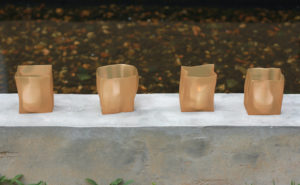four mini luminarias on a short concrete wall